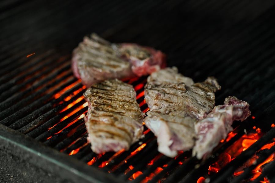 Steak grilling over open flame at Monaco